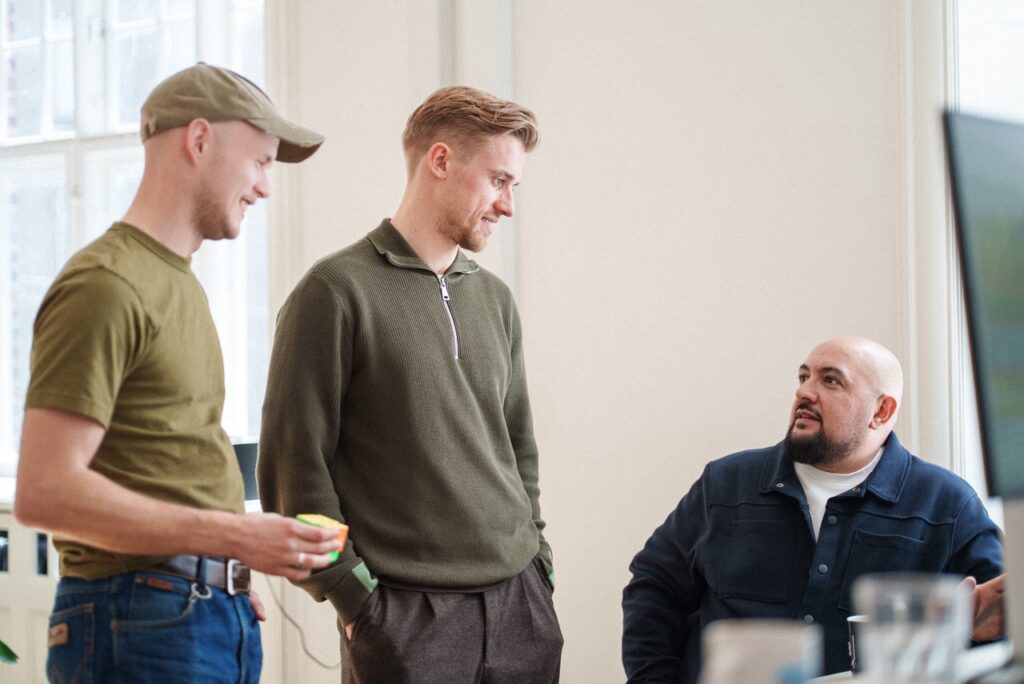 The team at Good Tape engaged in conversation in the office